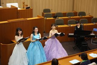 ドレスを着た東邦音楽大学学生3名による声楽アンサンブルが披露されている写真