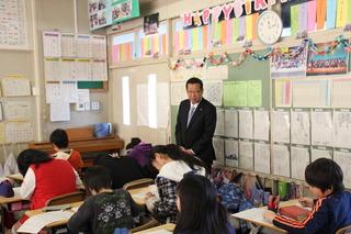 さぎの森小学校にて授業で生徒が教科書を見ている様子を市長が見学している写真