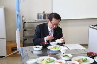 調理された料理を試食する市長の写真
