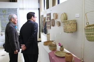 資料館友の会の竹細工の展示をスタッフと一緒に鑑賞する市長の写真