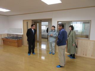 関係者3名から真新しいホールの説明を受け見学をしている市長の写真