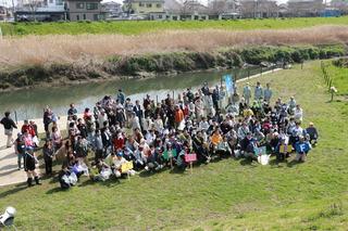 河川敷で参加者全員で記念撮影している写真