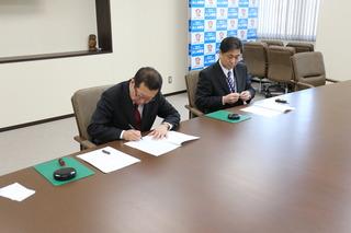 株式会社ゼンリンの代表と市長がお互い協定書に調印している写真