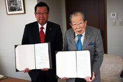 赤いネクタイの市長と青いネクタイの聖路加国際病院理事長日野原先生と調印式での写真