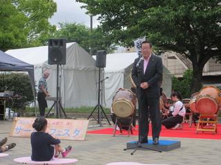 和太鼓が設置されているふじみ野で輝くサークルフェスタのステージで市長が挨拶している写真