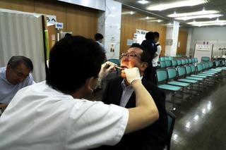 歯科医師に口の中を見てもらって歯の検査を受けている市長の写真