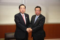 太田 昭宏国土交通大臣と市長が両手でしっかり握手をしている写真