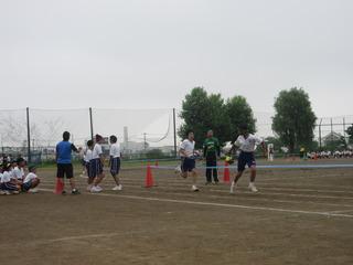 中学校の体育祭で青いテープの間を走っている生徒たちの写真