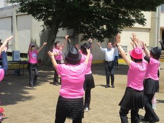 元気・健康フェアにてグラウンドでピンクのTシャツを着ている団体と市長が輪になって手を上げている写真