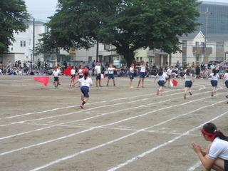スタートしてゴールに向かい走っている女子徒競走の後ろ姿の写真