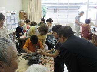 子供たちが粘土で工作をしている様子を見ている市長の写真