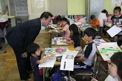 亀久保小学校にて絵日記を書く生徒に話を聞く市長の写真