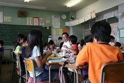亀久保小学校にて生徒と一緒に給食を食べる市長の写真