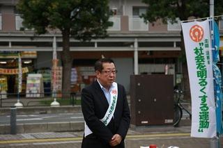 上福岡駅西口ココネ広場で肩にタスキをかけた市長が話をしている写真