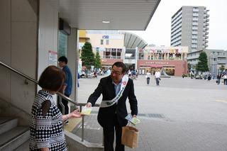 市長が駅の階段から降りてくる女性に、キャンペーンのチラシを手渡ししている市長の写真