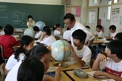 大井中学校にて地球儀を見ている生徒たちを見学する市長の写真