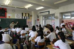 花の木中学校にて黒板で先生が生徒に説明している様子を見学する市長の写真