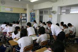 花の木中学校にて生徒の机の横で授業を見学する市長の写真