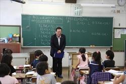大井小学校の教室で、着席する生徒の前に立ち、話をする市長の写真