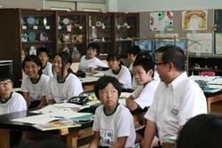 葦原中学校にてグループ分けされた机に生徒と一緒に座る市長の写真