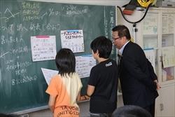 上野台小学校の生徒2人と、黒板の前に立つ市長の写真
