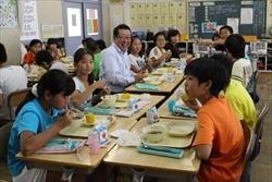 上野台小学校の生徒と、一緒に給食を食べる市長の写真