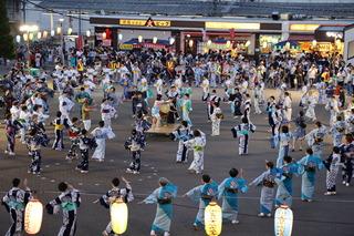 広場の中央の和太鼓を囲んで、色とりどりの浴衣を着た踊り子の方々が輪になって踊っている写真