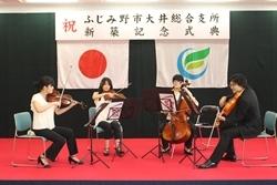 ステージ上で、バイオリンなどの弦楽器を座って演奏している男女4名の写真