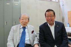 後ろにロッカーのある部屋で、日野原 重明さんと右隣りに市長2名の記念写真