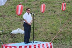 紅白幕がまかれた指揮台に立ち、話をする市長の写真