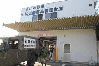防災備蓄管理倉庫の玄関前につけられた自衛隊車両の写真