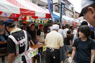 通りいっぱいに模擬店が並び、お店の方が通りを通るお客様に声をかけており、通りにも沢山の人が行き来して大変賑わっている様子の写真