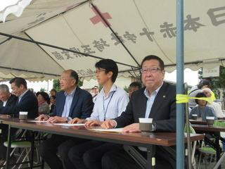テントの中の来賓席に市長と来賓者が座っている写真