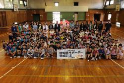 鶴ケ丘小学校の体育館で認知症サポーター養成講座の参加者全員で記念撮影している写真