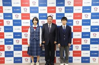 制服姿の麻生さんと中島さんの真ん中に市長が立ち並んで写した写真