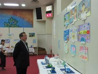 壁に展示された作品の絵を見ている市長の写真