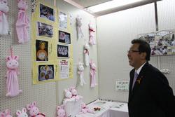 壁に貼られた写真とウサギの作品を笑顔で見ている市長の写真