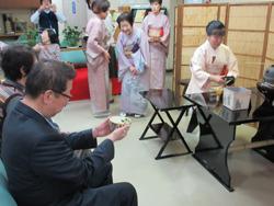 お茶会の席にて、市長がお茶椀を両手に持ってお茶碗を眺めている写真