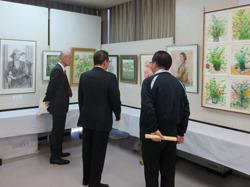 絵画が展示されているコーナーで市長と関係者の男性2名が絵画を見ながら話をしている写真