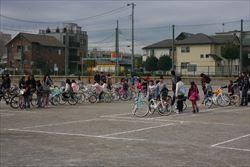 グラウンドに自転車をもって並ぶ子供たちの写真