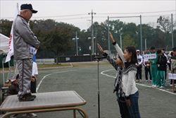 指揮台に立つ男性の前で、選手宣誓をする女の子2名の写真