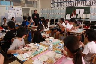 給食を食べている子供達に話しをしている市長の写真