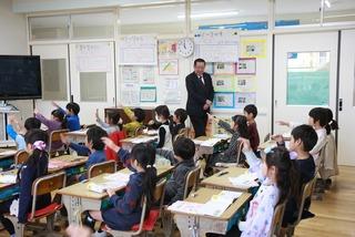 授業中にたくさんの子供達が手を挙げている様子を見学している市長の写真