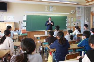 教室の黒板の前に立ち生徒達に話をしている市長の写真