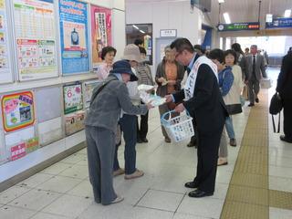 駅で市長が市民に資料を配り春の全国交通安全運動を呼びかけている写真