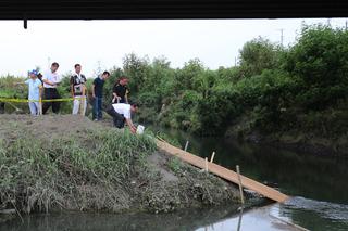 河川敷にて福岡河岸まつりの灯篭を流す板の周りに関係者たちが立っている写真