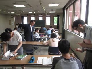 勉強する子供達と教える講師の方の様子を見学する市長の写真