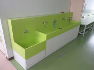 黄緑色に塗られている真新しい手洗い場の写真
