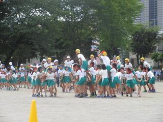 黄色い帽子を白い帽子を被ったチームに分かれて騎馬戦の競技が行われている写真