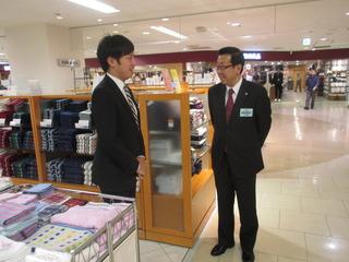 店内のタオル売場で、市長と職員の男性が話をしている写真